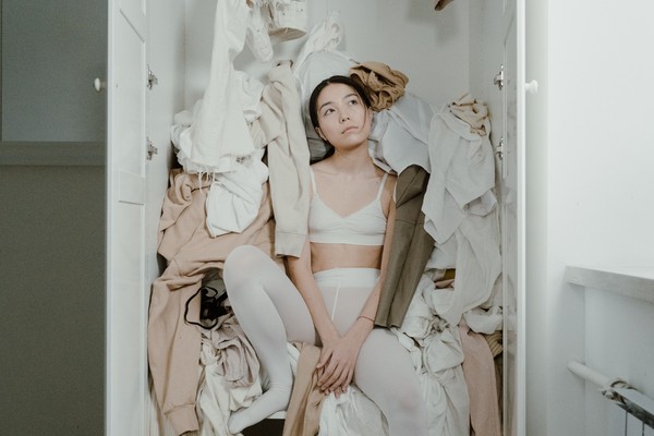 A closet stuffed with fall clothes, spilling out onto the floor